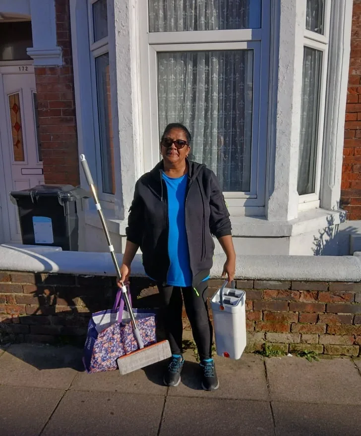 Leila from Leila & Dave's Cleaning Services outside a Southsea terrace with her cleaning kit